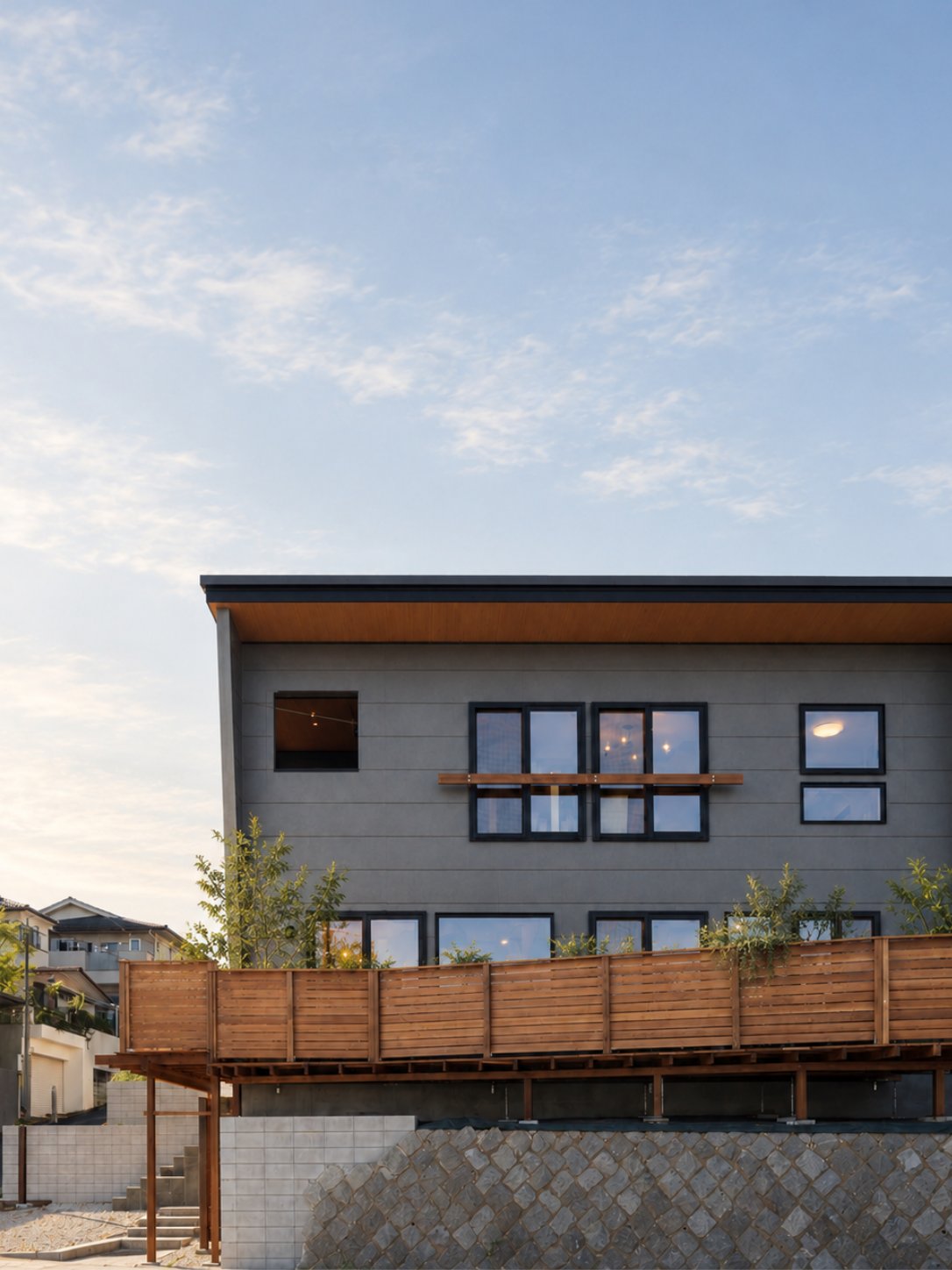 角地に建つ、ウッドデッキが囲む外観